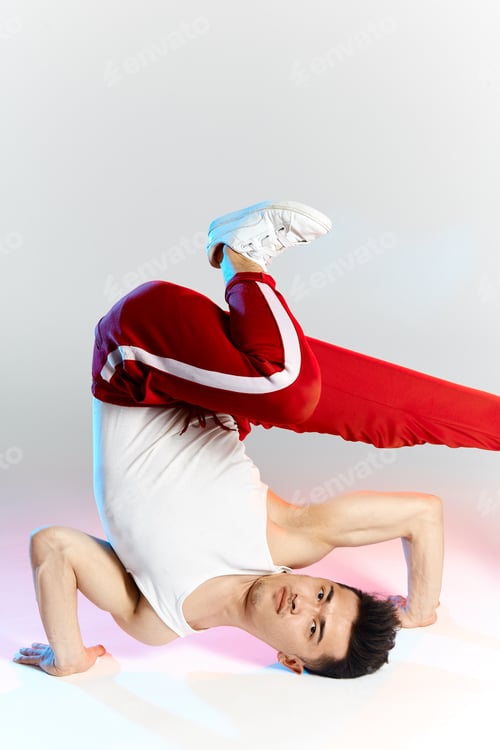 Preview: asian b-boy exercising in break dance on white background doing shoulder freeze