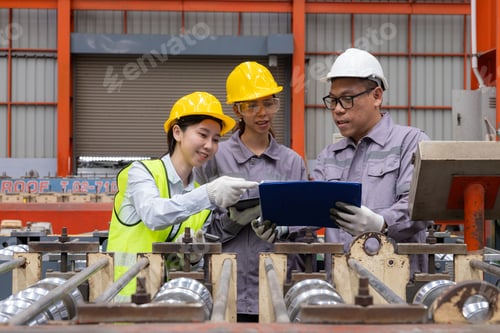Preview: Engineers discussing machinery in manufacturing plant