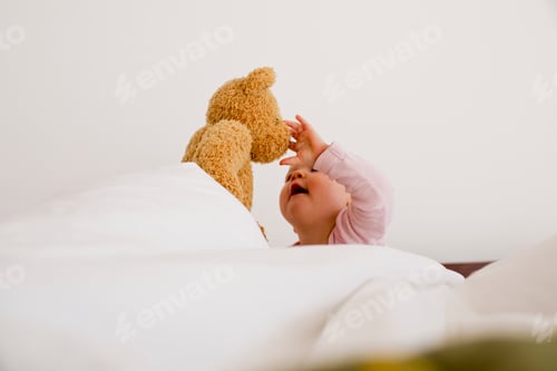 Preview: Baby girl playing with teddy bear
