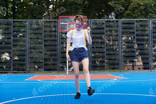 Preview: Active smiling dancing teenage girl on street basketball court