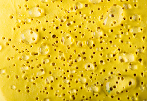 Close-up of a Textured Yellow Surface with Holes