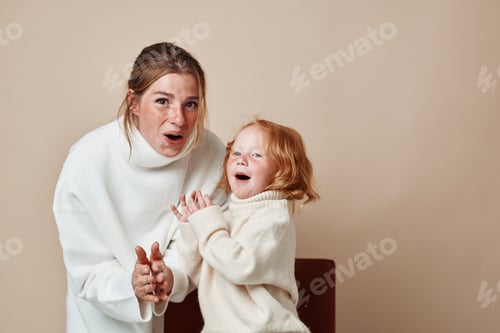 Preview: Mother and daughter enjoying fun time together against beige background in family happiness concept