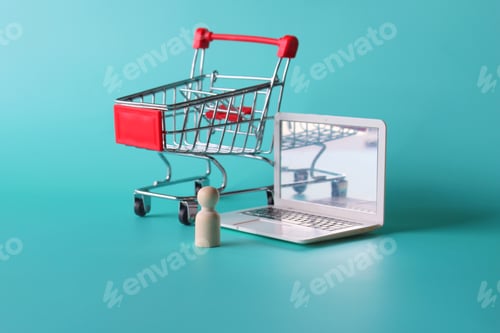 Preview: Wooden doll in front of laptop and shopping trolley