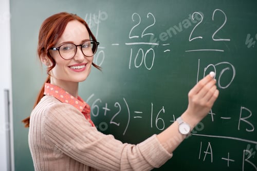 Preview: Experienced math teacher standing near blackboard with chalk