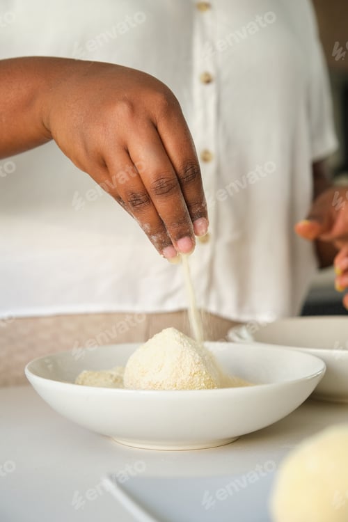 Preview: Close up of cuban woman hands breading mashed potatoes balls.