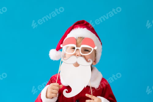 Preview: Funny child dressed Santa Claus costume against blue background