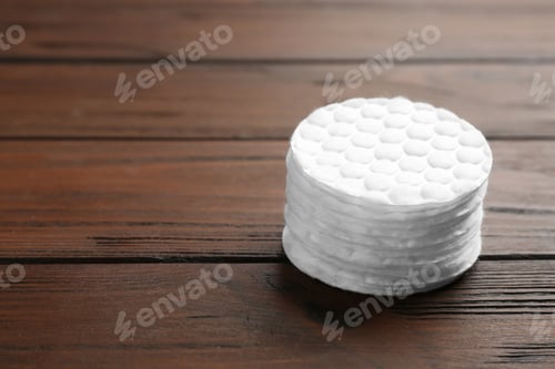 Preview: Stack of cotton pads on wooden background. Space for text