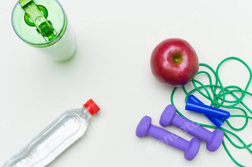 Preview: Healthy snack and fitness equipment arranged on a clean white surface for a workout session