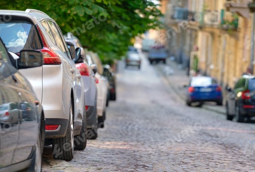 Preview: City traffic with cars parked in line on street side.