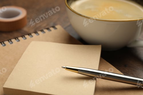Preview: Pen, sticky notes, notepad and cup of coffee on table, closeup