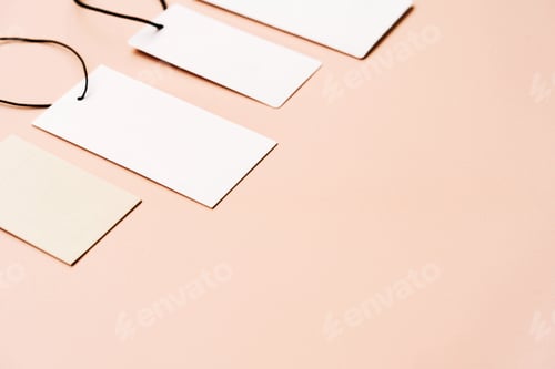 Preview: White price labels, blank tags with different shapes and sizes on a beige background.