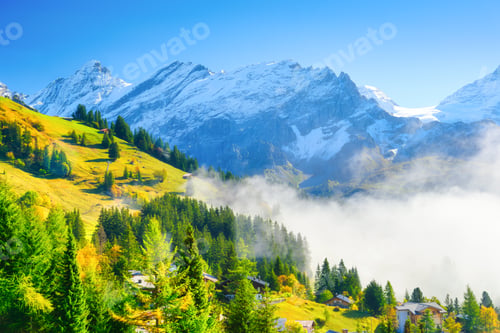 Preview: Village in Switzerland. A sunny day and a mountain valley. Houses on the mountains background.