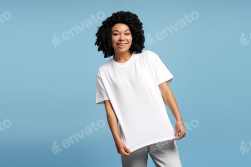 Preview: Portrait of young African American woman in oversized t-shirt on blue background