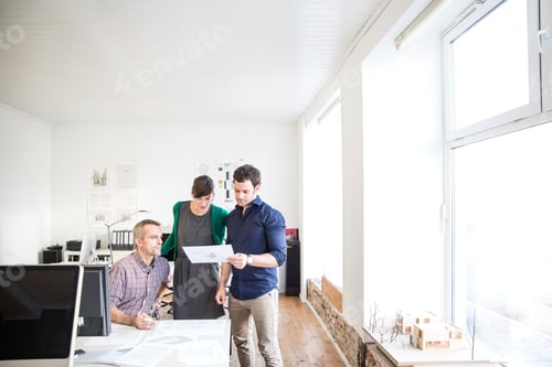 Preview: Colleagues at desk in office discussing paperwork