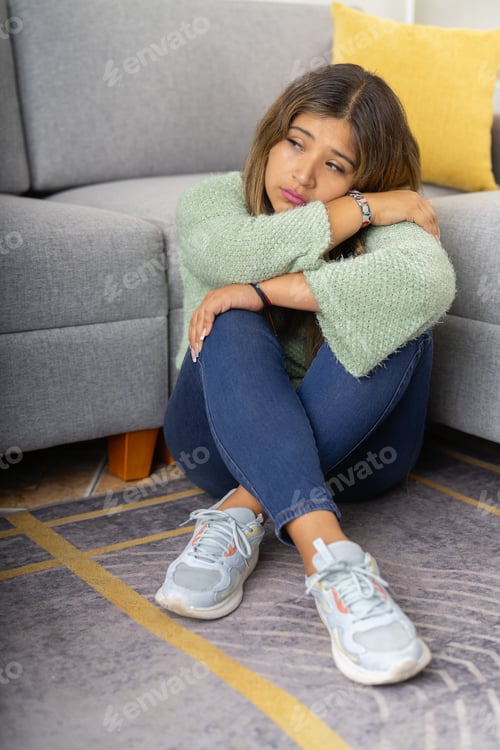 Preview: Depressed woman sitting on a corner of a house