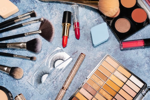 Preview: set of decorative cosmetics, makeup brushes on a blue background. the view from the top