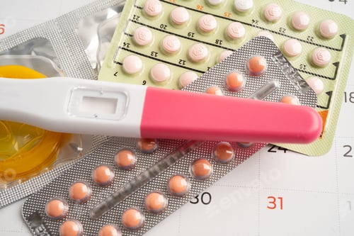 Preview: Pregnancy test and birth control pills on calendar, contraception health and medicine.