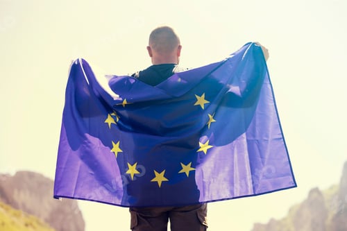 Preview: Man with EU flag over blue sky