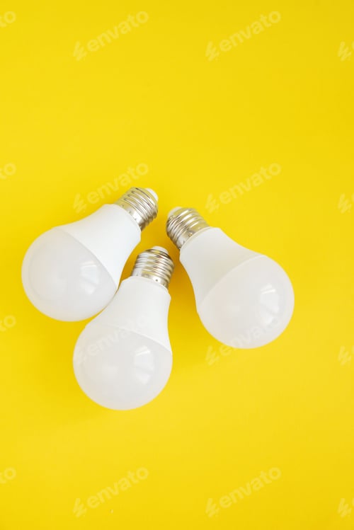 Preview: Three LED light bulbs on yellow background. energy saving concept.
