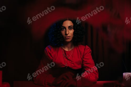 Preview: young fortune teller looking at camera on dark background with red smoke