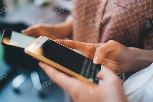Preview: Crop women browsing smartphone at workplace