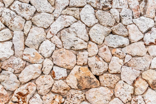 Preview: Weathered stone wall is covered with an intricate mosaic of variously-sized rocks.