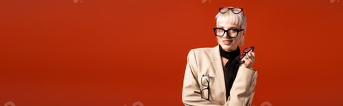 Preview: Young woman with stylish glasses and a bright smile against a vibrant red background