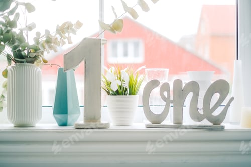 Preview: Wooden letters for 1 year birthday on a windowsill at home.