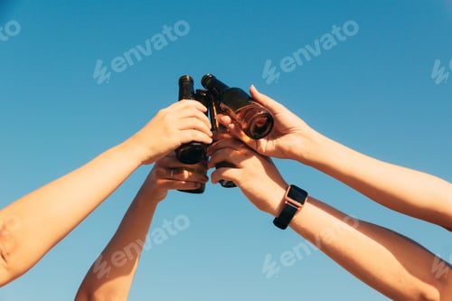 Preview: Closeup shot of bottles lifted high on blue sky background