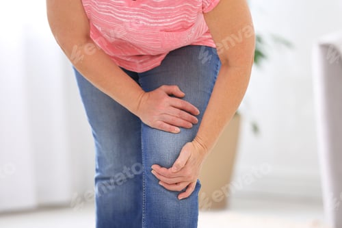 Preview: Senior woman suffering from knee pain at home, closeup
