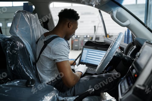 Preview: Male mechanic using laptop, car service