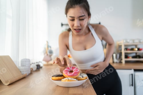 Preview: Asian beautiful young girl hungry and want to eat donut in kitchen.