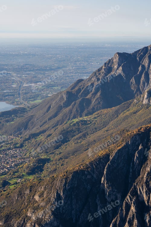 Preview: Beautiful landscape of the misty hazy Italian Alps mountain range during evening. Lombardy, Italy