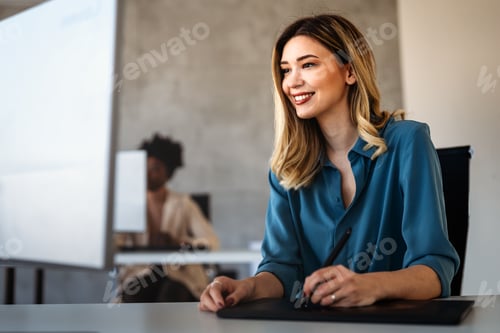 Preview: Young successful business woman using a computer while working in a startup company office