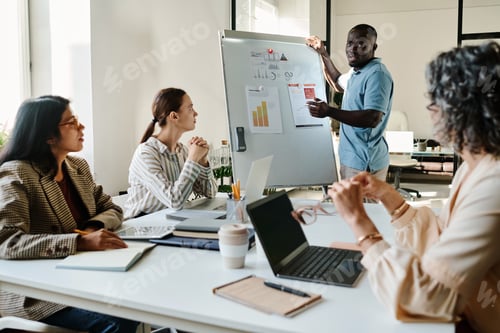 Preview: Young African American male economist standing by whiteboard