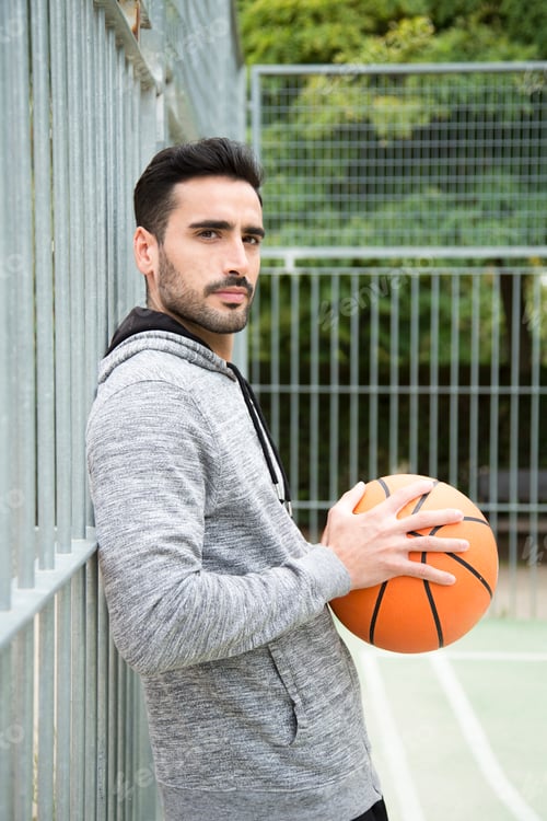 Preview: Man turning to face the camera holding a basketball ball