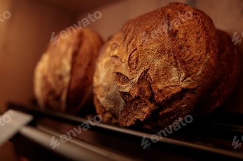 Preview: Freshly baked loaf of artisanal bread with a light dusting of flour on its golden brown crust