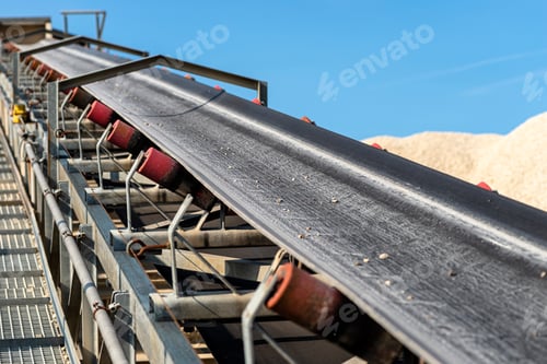Vista previa: Close-up shot of the conveyor belt in the concrete plant with transport rollers, visible metal stair