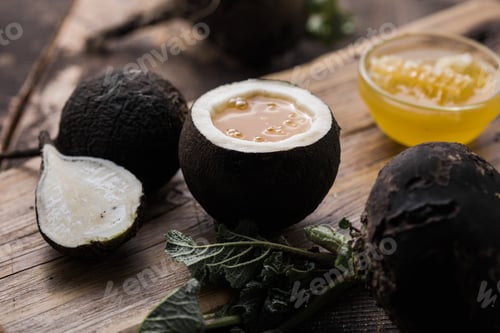 Preview: Organic raw Black radish with honey on wooden table. Homemade cough medicine.