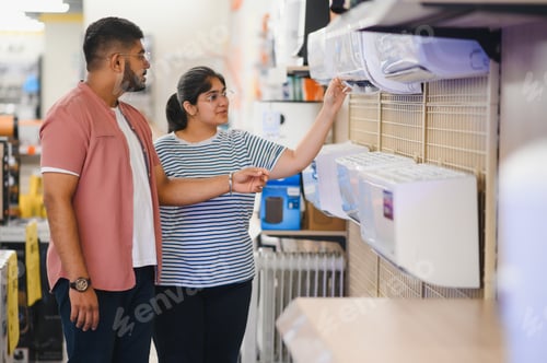 Preview: A beautiful indian couple chooses an air conditioner at home in an electronics store.