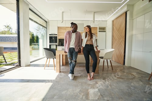 Preview: Young romantic mixed-race couple standing in kitchen