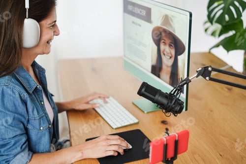 Preview: Influencer woman streaming live podcast with mobile phone at home - Soft focus on female eye