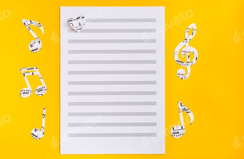 Preview: Blank sheet music, music notes and hearts cut from music text on yellow background. Top view