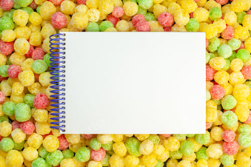 Preview: High resolution photo of spiral notebook on coloured sweets covering full background