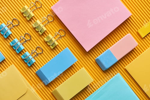 Preview: flat lay of colorful arranged stationery supplies on yellow
