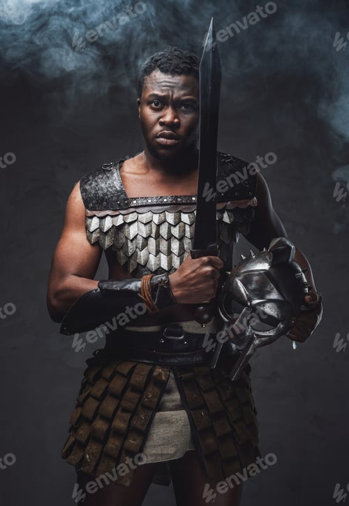 Preview: Authentic roman gladiator stares to camera on gray background