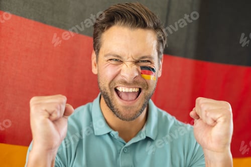 Preview: Image of happy caucasian man with flags of germany on face over flag of germany
