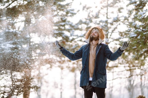 Preview: Portrait of young man in snowy winter forest. Season, christmas, travel and people concept.
