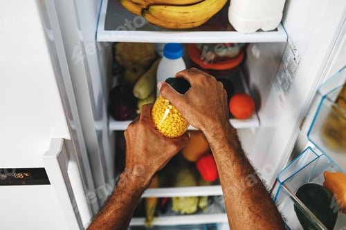 Preview: Male hands taking canned corn jar from fridge