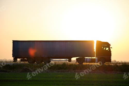 Preview: Semi-truck with cargo trailer driving on highway hauling goods in evening